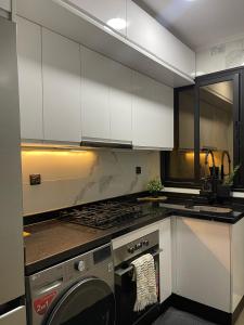 Una cocina con gabinetes blancos y lavadora. en Luxury appartement with Private Parking For families only, en Tánger