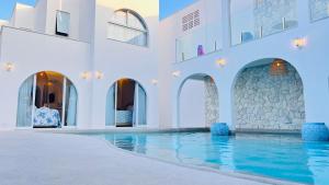 a pool in a building with white walls and water at D'Blue Búzios Hotel Boutique in Búzios +112 photos
