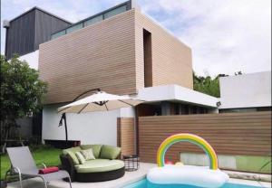 Casa con piscina, silla y sombrilla en Luxury Pool Villa 107, en Bangkok