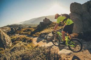 a man riding a bike on a rocky hill at Parkwood 5 - 2BR Split Level l Spa Bath l BBQ l Central Location l WiFi in Jindabyne