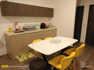 Una cocina con una mesa blanca y sillas amarillas. en l Brand New Condo l I-Muslim Guesthouse Kuala Lumpur, en Kuala Lumpur