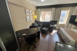 a hotel room with a desk and a bed at Flat R. Maestro Cardim Benef Portuguesa (Apto 110) in Sao Paulo