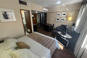 a bedroom with a bed and a living room at Flat R. Maestro Cardim Benef Portuguesa (Apto 110) in Sao Paulo
