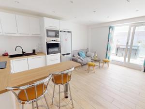 a kitchen and living room with a table and chairs at Appartement moderne 3 chambres, terrasse, proche plage et commerces - FR-1-785-12 in Mèze