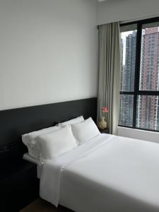 a bedroom with a large white bed and a window at Luxury AI Smart Home in KL in Kuala Lumpur