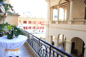 a balcony with a table with a bouquet of flowers at AX The Victoria Hotel in Sliema