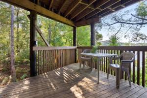 Una terraza de madera con una mesa y sillas. en Bushview Retreat, en Paihia