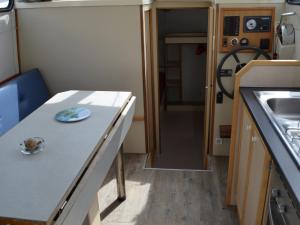 a kitchen with a table and a sink in a trailer at Bateau confortable à quai pour 5 pers, Pontailler-sur-Saône, proche commerces - API-1-46-16 in Pontailler-sur-Saône