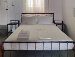 a large bed with white sheets and white pillows at Φως (Fos) in Astypalaia Town