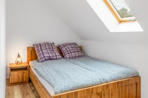 a bedroom with a wooden bed with two pillows at Domki Niedźwiadki nad morzem in Kopalino