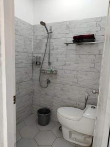 un bagno bianco con wc e doccia di TUTUP Permanen a Muntilan