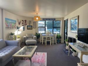 a living room with a couch and a table at Oceanside to Seaside 334 in Mount Maunganui