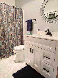 Un baño con lavabo, inodoro y espejo. en Walk to Downtown , 7 Guests , Pets , AC, No Stairs, en Leavenworth 22 fotos más