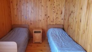 two beds in a room with wooden walls at Holiday Cottage in Ureki, Georgia in Ureki