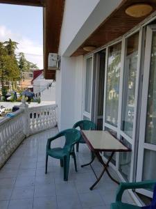 a porch with a table and chairs on a balcony at Holiday Cottage in Ureki, Georgia in Ureki +11 photos
