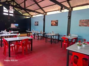 a dining room with tables and red chairs at Rose Guest House in Canhangdon