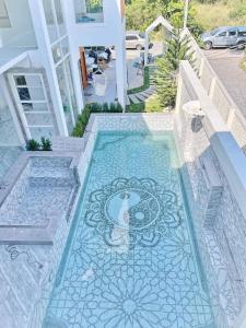 a swimming pool with a mosaic floor in a house at Luxury Pool Villa 99 in Ban Bang Krang