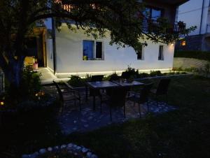 a table and chairs in front of a house at night at Kavkaz Apartment in Sarajevo
