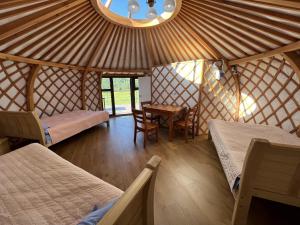 a room with two beds and a table in a yurt at Magic Rock Tourist Camp in Nalayh