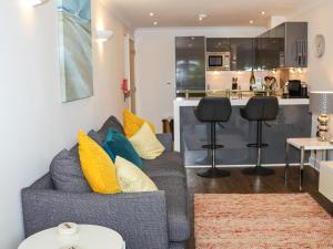 Una sala de estar con un sofá y una cocina. en Serendipity, en St Ives