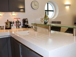 Una cocina con un fregadero y un reloj en la pared. en Serendipity, en St Ives 15 fotos más