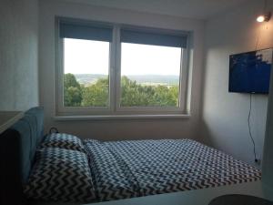 a bedroom with a bed in front of a window at WUGE Bihac in Bihać