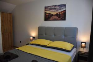a bedroom with a bed with yellow sheets and a painting on the wall at Apartments Rismondi 37D in Fažana