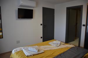 a bedroom with a yellow bed with towels on it at Apartments Rismondi 37D in Fažana