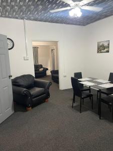 a living room with a table and a couch and chairs at Breeze Manor in Scarborough