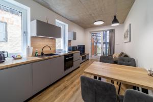 a kitchen and dining room with a wooden table at CASTLE apartments - City Center in Spišské Podhradie