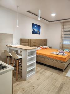 a bedroom with a bed and a table with chairs at Lena Apartman in Lastva