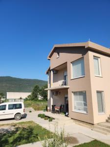a house with a van parked in a driveway at Lena Apartman in Lastva