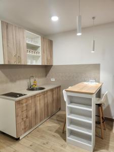 a kitchen with wooden cabinets and a sink and a table at Lena Apartman in Lastva +22 photos