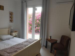 a bedroom with a bed and a chair and a window at Les Lézards 2 au Soleil Draguignan in Draguignan