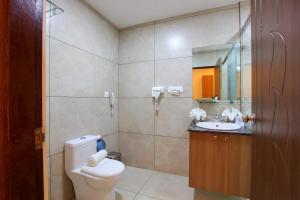 a bathroom with a toilet and a sink and a mirror at Enkeys Residency in Alleppey +20 photos