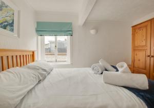 a bedroom with a white bed with towels on it at 2 Copper Kettle Apartment in St Ives