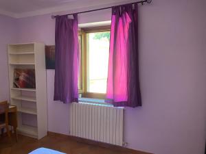 a room with a window with purple curtains at Appartamento Piazza Montese 2 in Montese