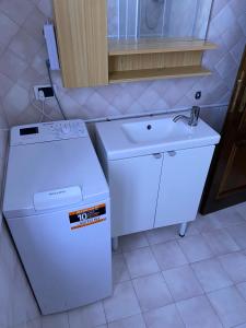 a white refrigerator and a sink in a kitchen at Appartamento Piazza Montese 2 in Montese