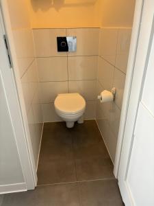 a bathroom with a toilet with a toilet paper dispenser at Apartament Street Art ZASPA - wśród murali in Gdańsk +32 photos