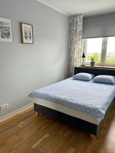 a bedroom with a bed and a window at Apartament Street Art ZASPA - wśród murali in Gdańsk