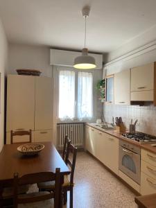 eine Küche mit einem Tisch und einem Tisch und Stühlen in der Unterkunft Nebula Nook Luxury Apartment in Modena