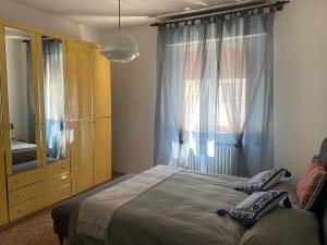 ein Schlafzimmer mit einem Bett, einer Kommode und einem Fenster in der Unterkunft Nebula Nook Luxury Apartment in Modena