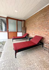 two beds in a room with a brick wall at De Pointé Resort & Resto in Campaka