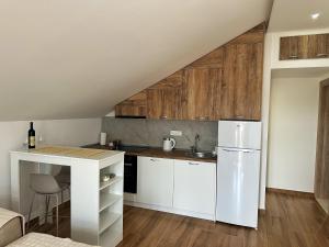 a kitchen with white cabinets and a white refrigerator at Nirvana S in Tivat