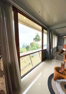 a room with a large window with a view at De Pointé Resort & Resto in Campaka