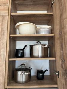 a wooden cabinet with pots and pans in it at Nirvana S in Tivat +6 photos
