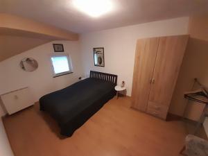 a bedroom with a black bed and a window at Ferienwohnung "Unter der Löwenburg" in Gerolstein