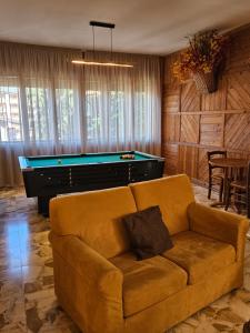 a living room with a couch and a pool table at Hotel Holiday Debili in Sauze dʼOulx