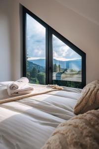a bedroom with a bed with a large window at Zawoja House in Zawoja