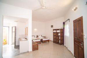 a room with white walls and a hallway with beds at HOTEL H1 ISALO in Ranohira